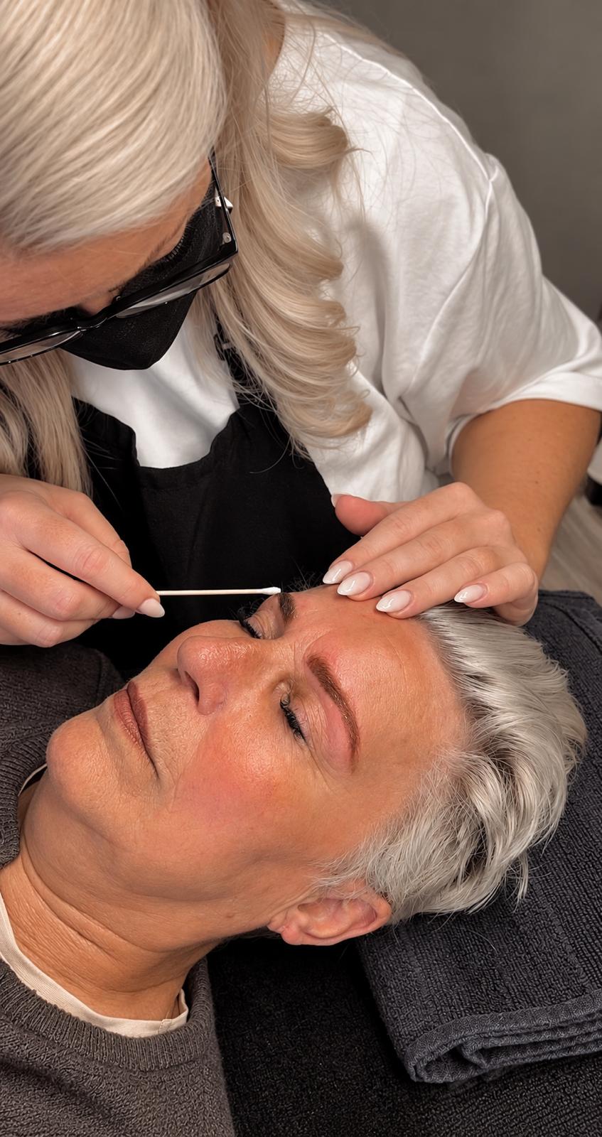 Kosmetikerin bei einer Wimpernbehandlung